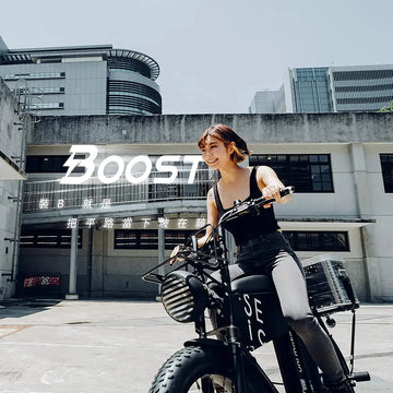 一位女生跨坐在黑色胖胎電輔車上，背後牆面印著大大的 Boost 字樣