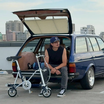 老車車友與 SEic CarryMe 摺疊車在頂樓停車場，後車廂備用代步車