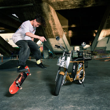 青少年在滑板場玩滑板，旁邊停著 Unimoke minibike 席勒泥 電輔車