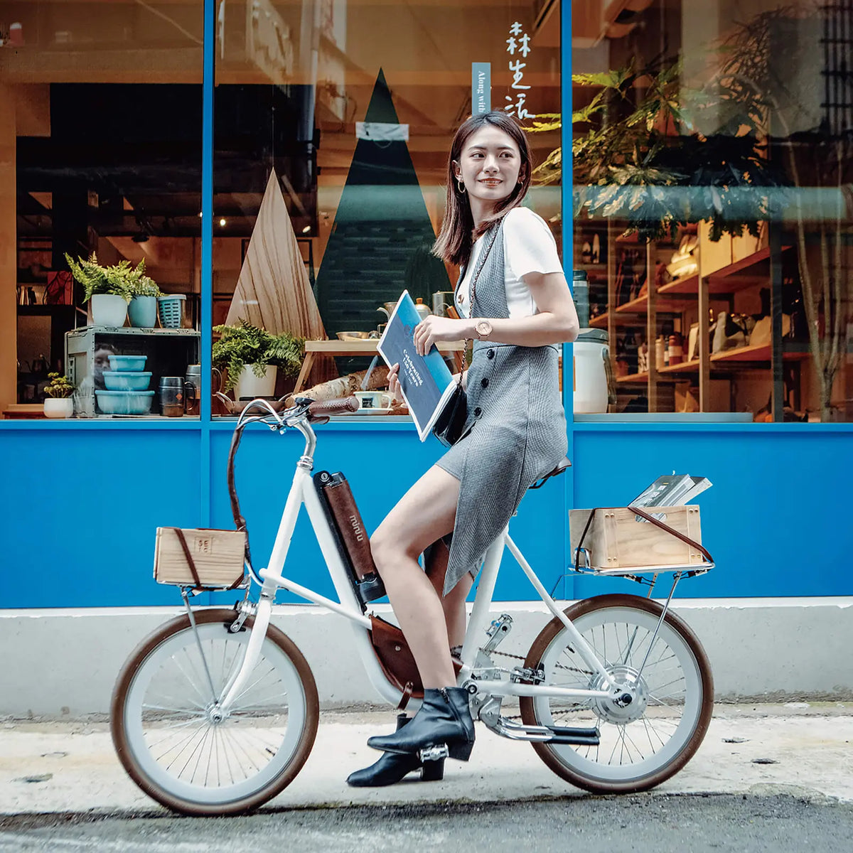 一名女性騎著電輔車 SEic miniu 珍珠白的文青風街拍，和諧且輕鬆