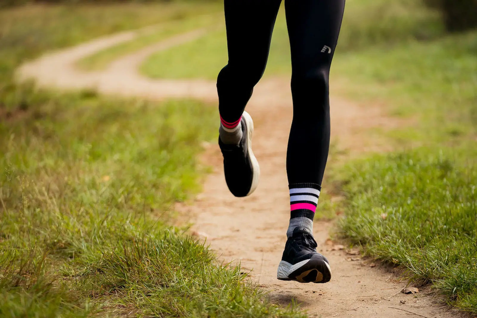一位跑者穿著運動緊身褲、 INCYLENCE Merino Strive 羊毛運動機能襪和運動鞋在跑步