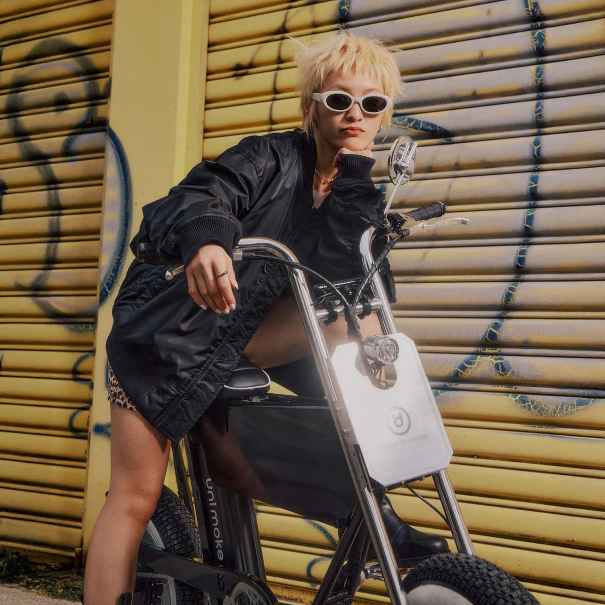 一個短金髮女子在街頭和 minibike 街拍，衣著搭配車款展現強烈個人風格
